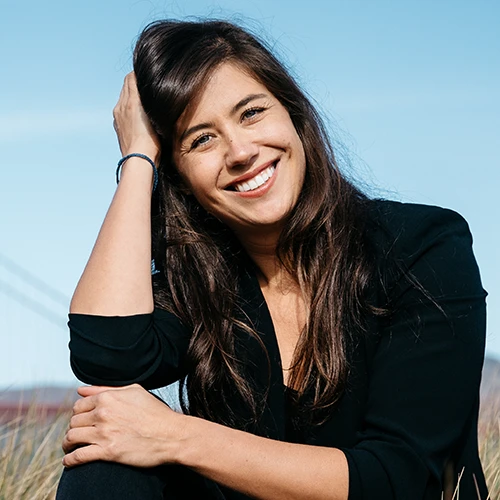 Headshot of Tara, smiling, outside, wearing a black shirt