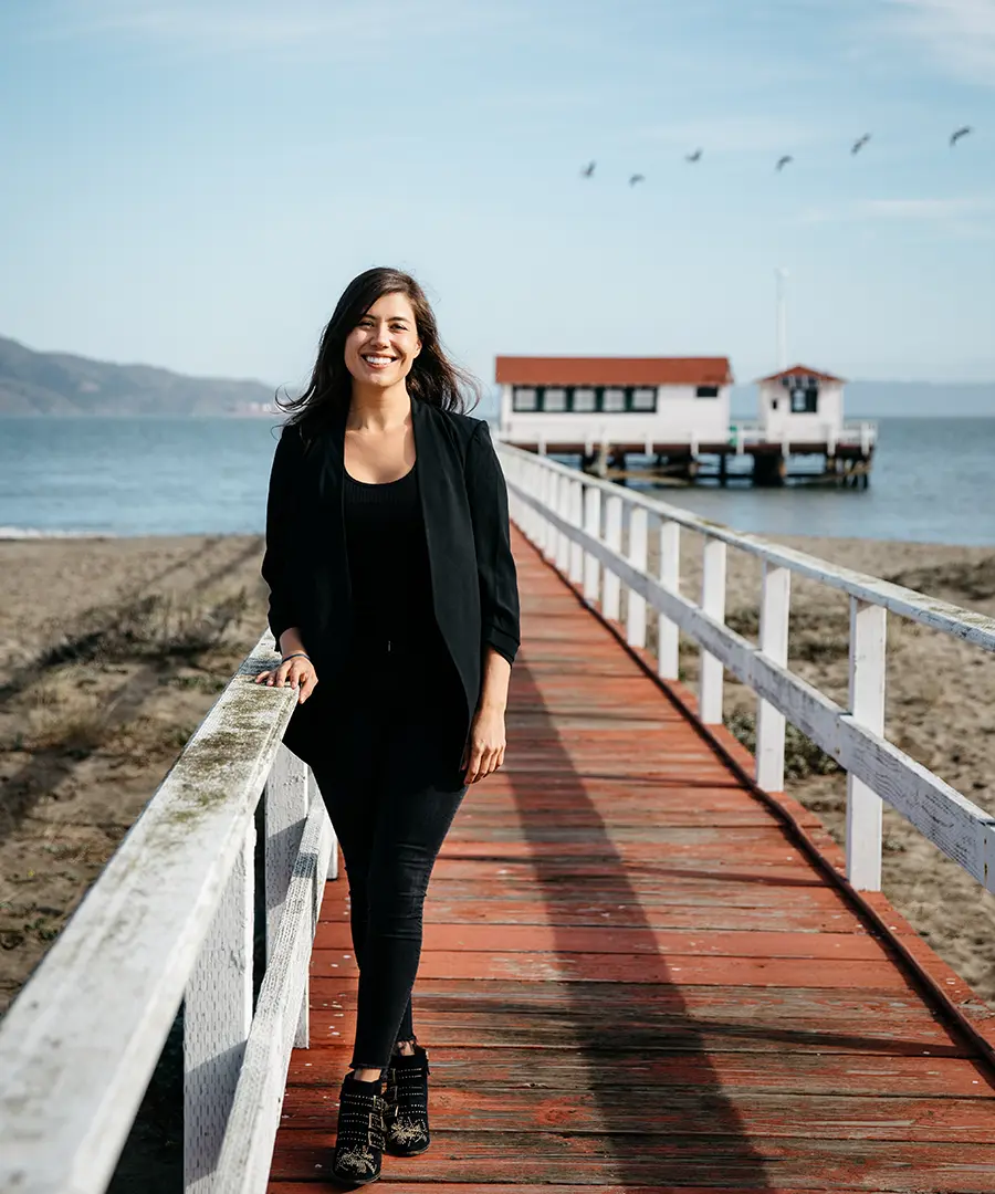 Tara in a navy blazer, outside, on a pier in San Francisco, smiling