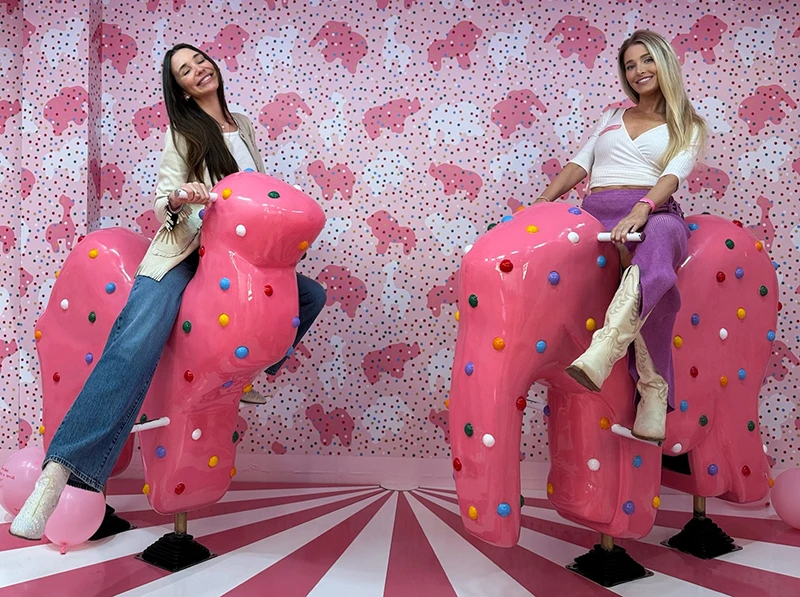 Blaine and Steph at the museum of ice cream, sitting on elephant-shaped seats